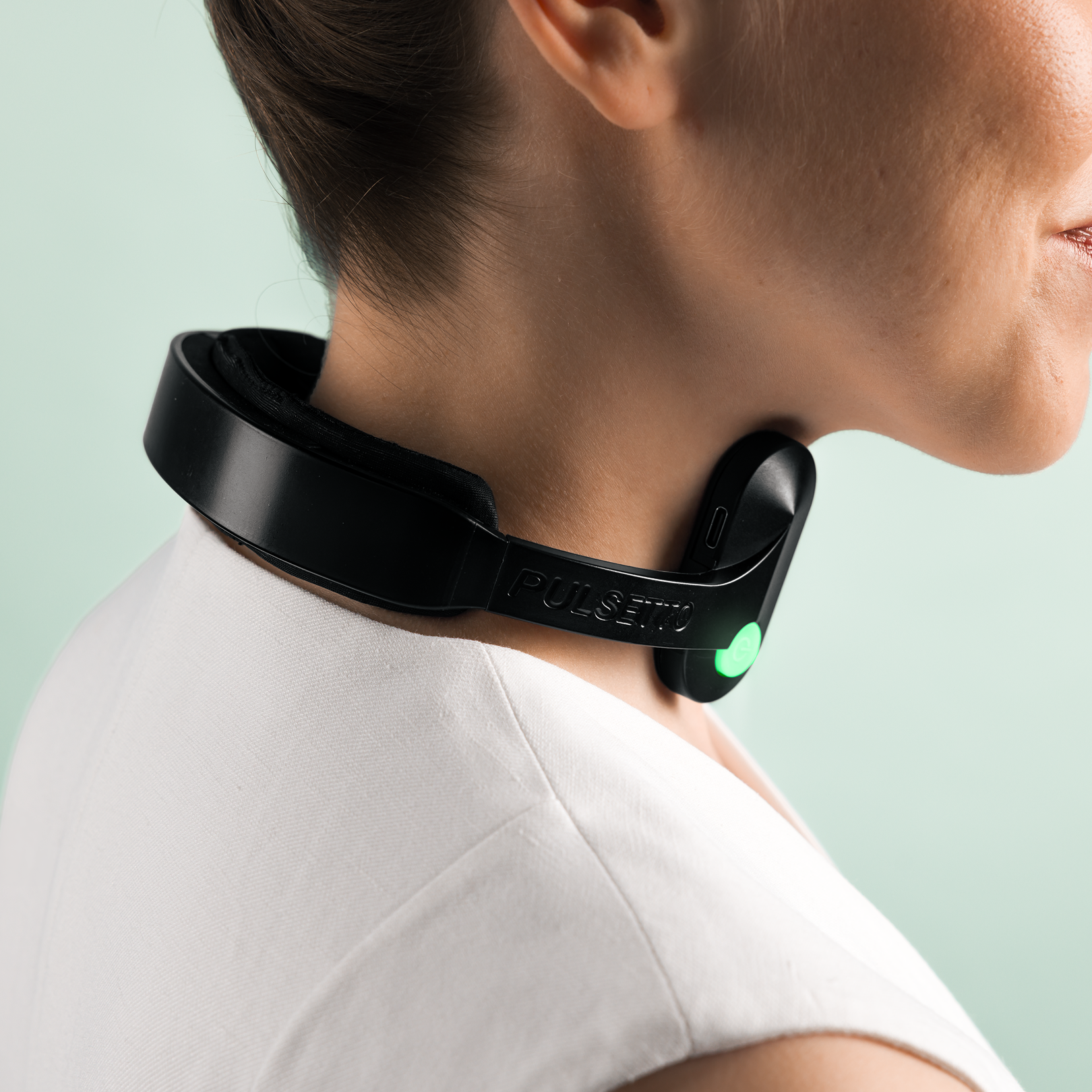 Person wearing a Pulsetto vagus nerve stimulation device around the neck